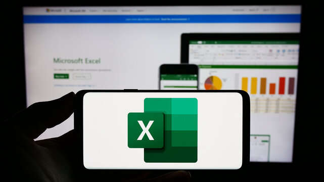 Stuttgart, Germany - 09-21-2023: Person holding smartphone with logo of spreadsheet editor Microsoft Excel on screen in front of website. Focus on phone display.