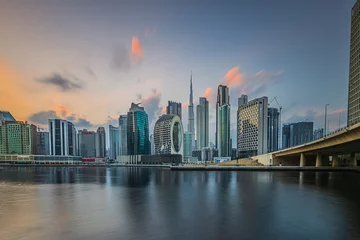 Fotobehang Skyline Port entrance in Dubai in the evening. Skyline view. Evening sun with clouds over city skyline of United Arab Emirates. City center with skyscrapers of business and office buildings at sunset