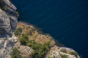 Rocky shore near the water, top view. Aerial view of rocks going into the water. Rocky coastline view from above.