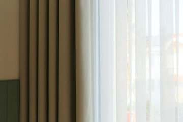 Cropped shot of drapes half covering the window. Close up, copy space for text, background.