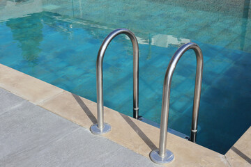 Close up shot of chrome pool handles. Copy space, background.