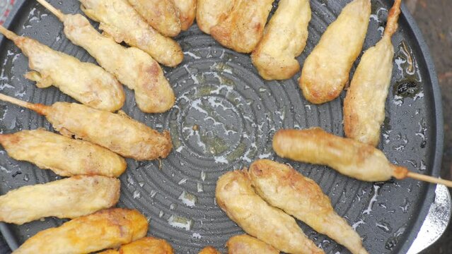 grilling sempol on a metal grill, traditional Indonesian food made from chicken and eggs