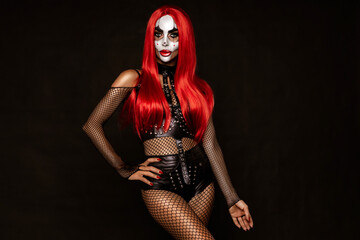 Sexy woman in a Halloween makeup and costume on black background. Halloween makeup and costume concept.