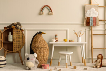 Warm and cozy kids room interior with white desk, stool, animal wicker basket, rattan sideboard,...