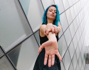 Young woman scratching on hand in front of modern building