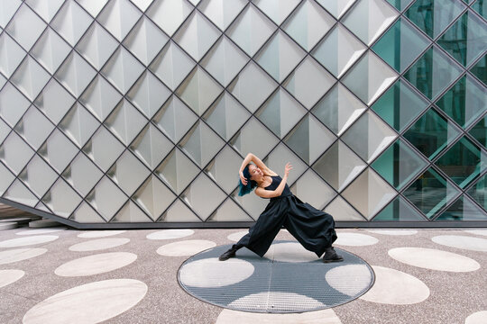 Dancer dancing in front of modern building