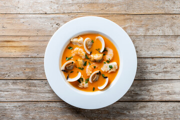 Seafood soup on wooden table. Top view