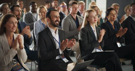 Crowd of Smart Tech People Applauding in Conference Hall During a Motivational Keynote Presentation By Innovative Company. Business Technology Summit Auditorium Room Full of Corporate Delegates.