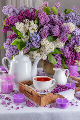 summer breakfast concept. tea in cups and lilacs on the table
