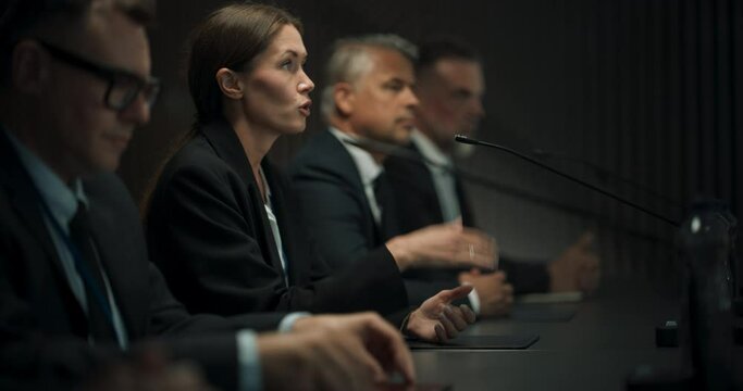 Zoom Out Shot: Caucasian Female Head Of Political Delegation Speaking At International Ecology Forum Press Conference. High-Profile Politician Reporting On Successful Deal. Diverse Delegates Listening