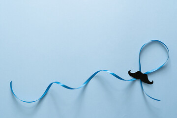 Movember concept - event to raise awareness of men's health issues, moustache anf blue ribbon - obrazy, fototapety, plakaty