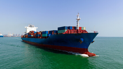 Fototapeta premium cargo container ship carrying in sea import export goods and distributing products to dealer consumers across Asia pacific and worldwide global business transportation by container ship open sea