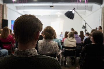 Fototapeta premium Unrecognizable people in the audience, rear view. Sitting at a lecture or meeting at the university. business and entrepreneurship or the concept of learning. High quality photo