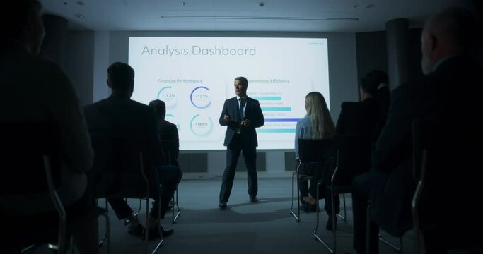 Caucasian Male Top Manager Walking Between The Rows Of Diverse Audience To Give Presentation At Business Conference. Successful Man Reporting On Revenue Growth, Business Objectives. Slow Motion.