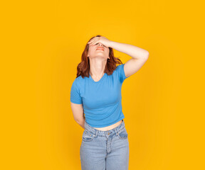 Ashamed woman epic fail, portrait of young caucasian bob hair troubled ashamed woman epic fail. Put hand on face facepalm. OMG gesture, leaning her head back. Standing over yellow studio backgorund
