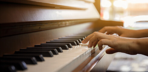 Close up of happy woman's hand playing the piano in the morning. - 653303622