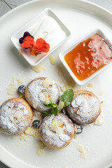 delicious breakfast - cheesecakes with sour cream and jam on a wooden table 