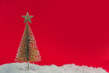 Christmas tree in the snow on a red background with place for text
