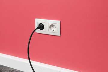 White double outlet on pink wall