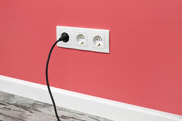 White triple outlet on pink wall