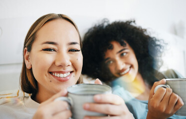 Coffee, smile and portrait of lesbian couple on bed in conversation for bond and relax together....