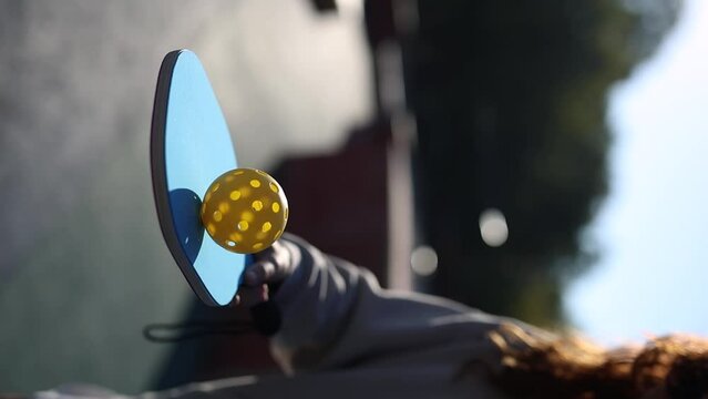 Ball spinning on a pickleball paddle in slow motion vertical video