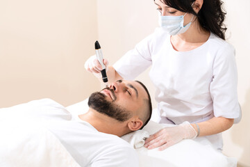 Obraz premium Dermastamp fractional mesotherapy for man in cosmetology clinic...