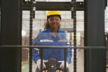 Female warehouse worker driving and operating on forklift truck for transfer products or parcel goods at storage warehouse