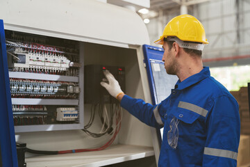 Male electrician engineer maintenance electric system in industry factory. Factory male worker at...