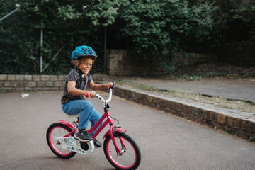 Happy girl riding bicycle in park