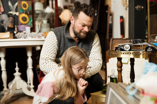 Father with daughter doing shopping in antique shop