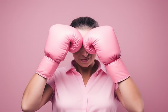 Beautiful woman with pink ribbon and boxing gloves