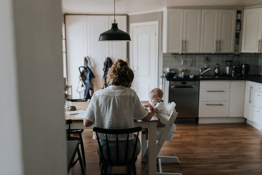 Multitasking mother taking care of baby and working from home
