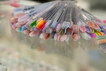 Collection of nails color polish samples. A palette of nail designs of different colors with gel...