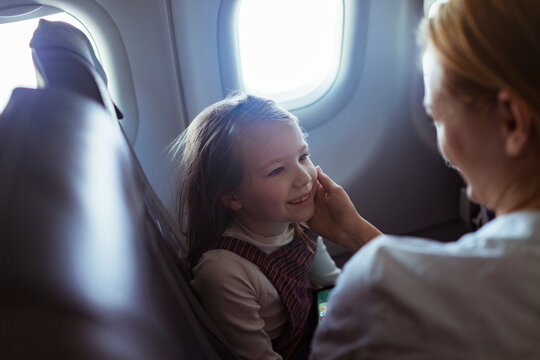 Young mother embracing her daughter on their flight