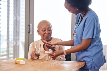 Nurse giving old woman pills in home with water for healthcare, wellness and help. Caregiver, medicine and African patient with glass to drink medical drugs, vitamins and supplements in retirement