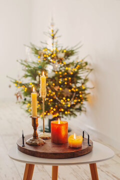 burning candles on table on background christmas tree at home