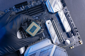 computer processor in a gloved hand against the background of the motherboard
