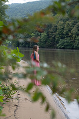 Beautiful woman on lake in pink dress
