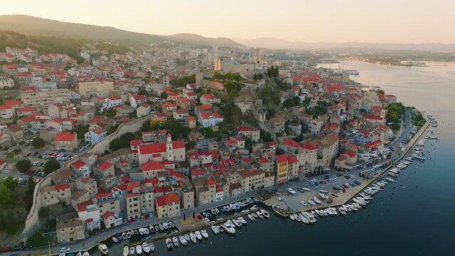Sibenik, Croatia - 4K flying by the famous St. Michael's Fortress and old town of Sibenik at sunrise on a sunny summer morning in Dalmatia