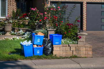 collection of  recycle  bins  and garbage bags on roadside for pick up on garabge day collection in...
