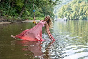 Having fun on a swing on the lake, ladies in pink