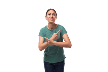 young slender european woman with ponytail hairstyle dressed in green t-shirt draws attention to advertising