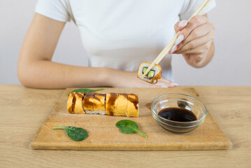  woman eating sushi. Cropped photo