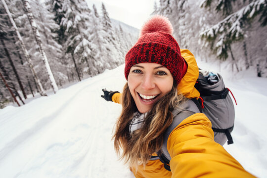 Happy woman hiker taking a selfie photo on a snowy mountain
