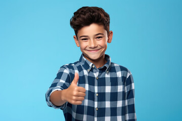 Boy wearing casual clothes standing over isolated blue background doing happy thumbs up gesture with hand