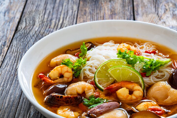 Yunnan hot pot - Chinese soup with shrimps on wooden table
