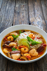 Yunnan hot pot - Chinese soup with shrimps on wooden table
