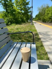 Goblet de café recyclable et compostable sur le siège d'un banc de parc. Air d'attente d'une...