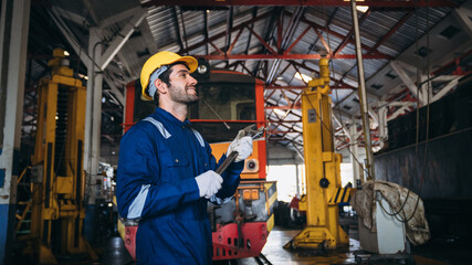 Portrait of Industrial engineers inspect and perform maintenance on the machines at factory machines. Teamwork in the Manufacturing Industry in train garage.